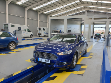 Ford Mondeo has it's suspension checked as part of ITV import test Ford Mondeo over inspection pit during ITV import test